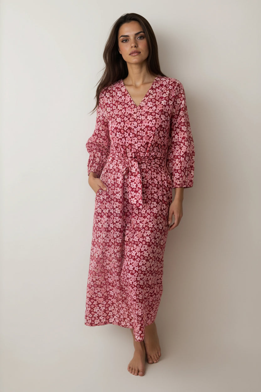 Woman wearing a pink floral dress against a plain background