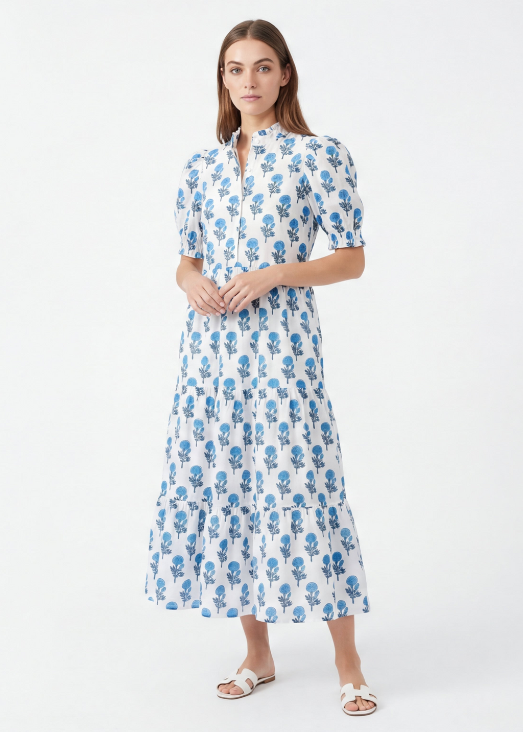 Woman wearing a white dress with blue floral pattern on a white background