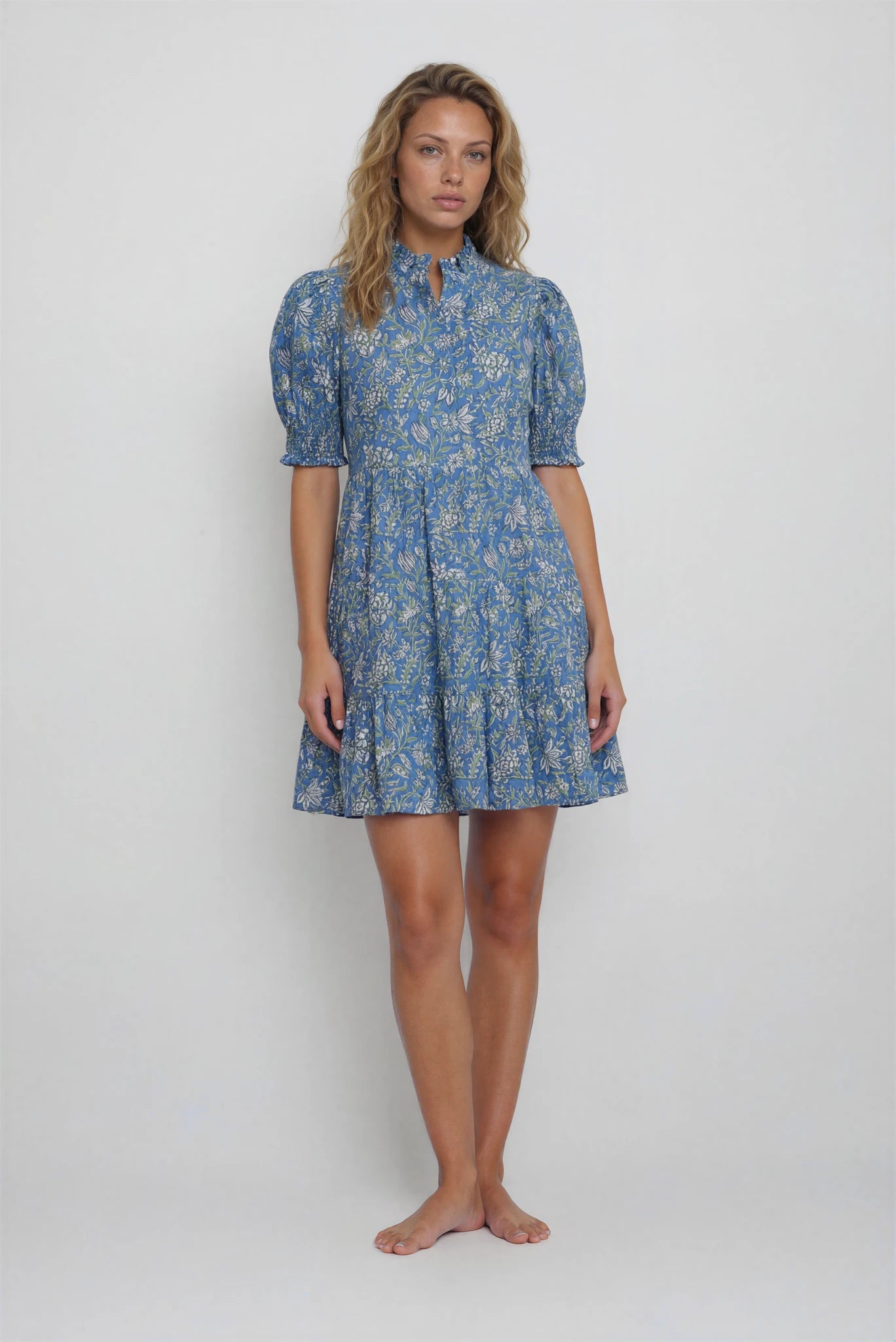 Woman wearing a blue floral dress on a white background