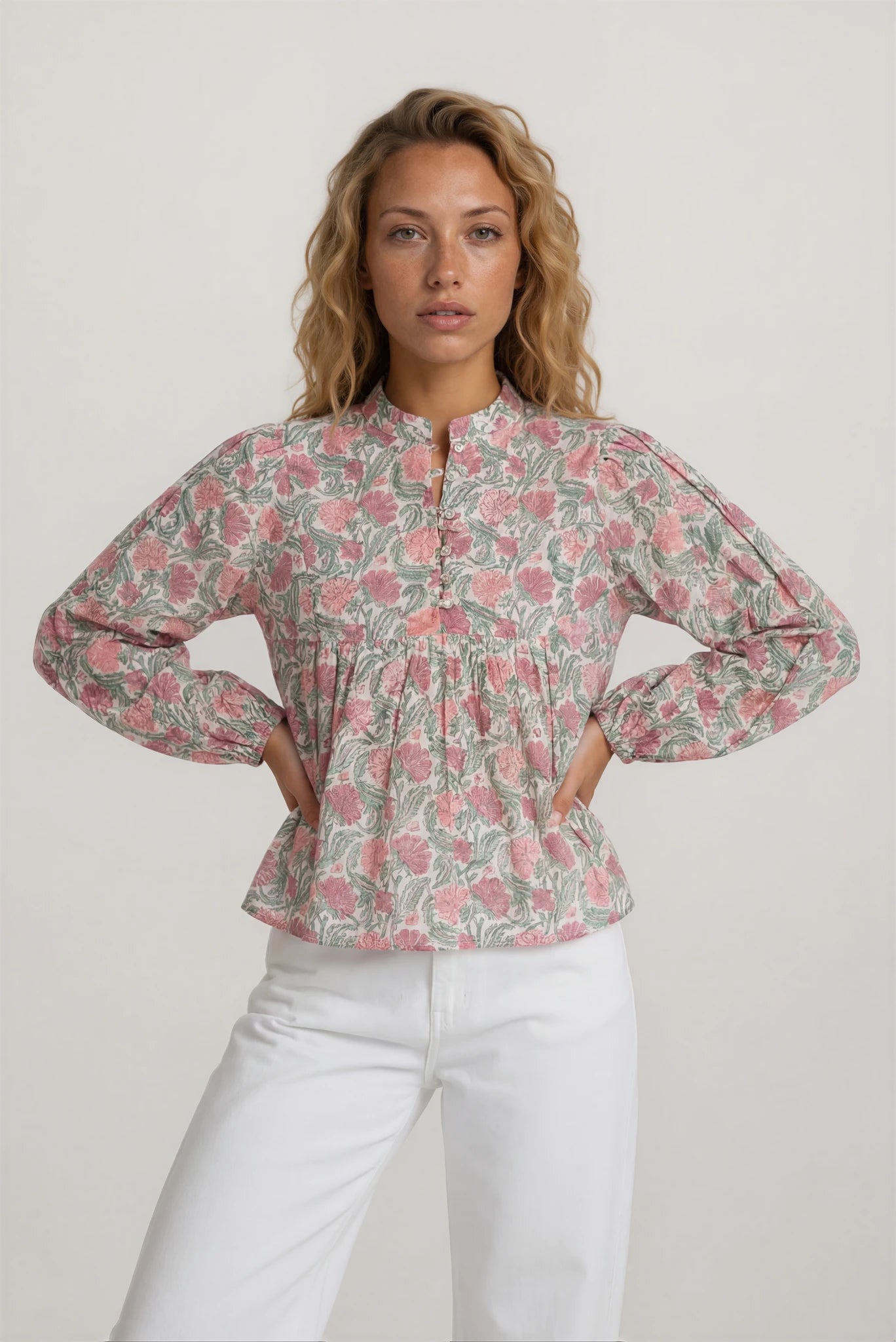 Woman wearing a floral blouse with long sleeves on a white background